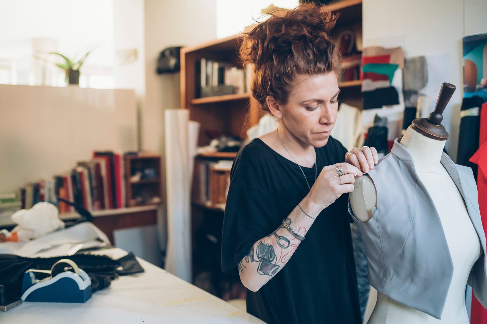 Fashion designer pinning garment onto dressmaker's dummy
